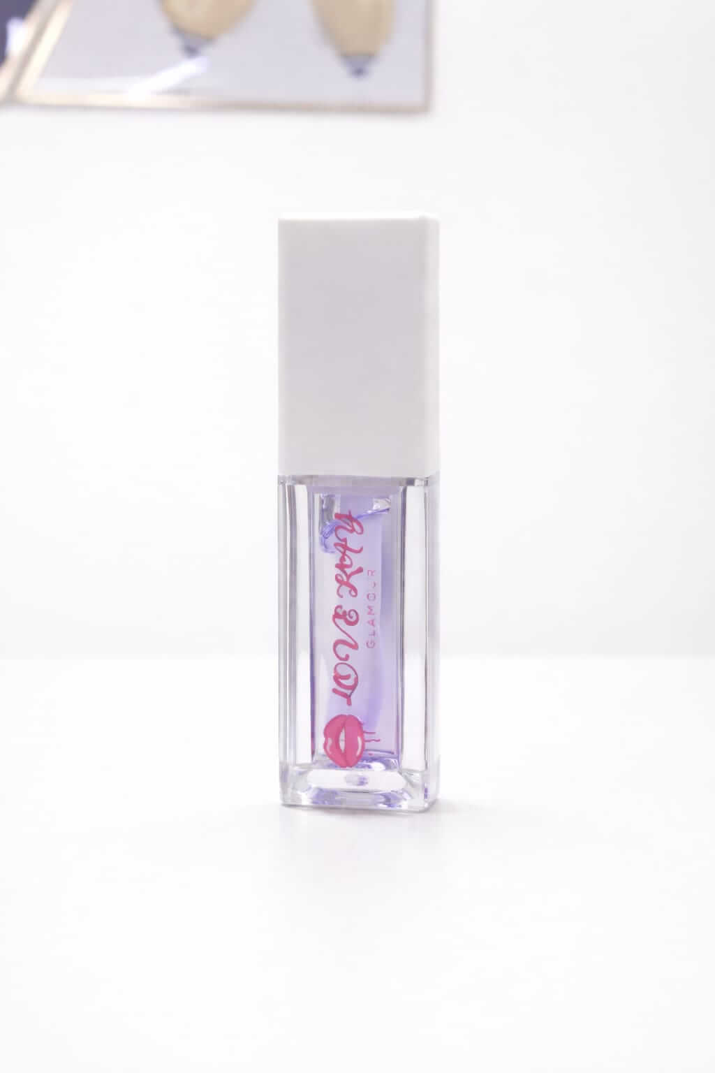 Purple Pop lip gloss in a clear tube with a white cap on a white background.