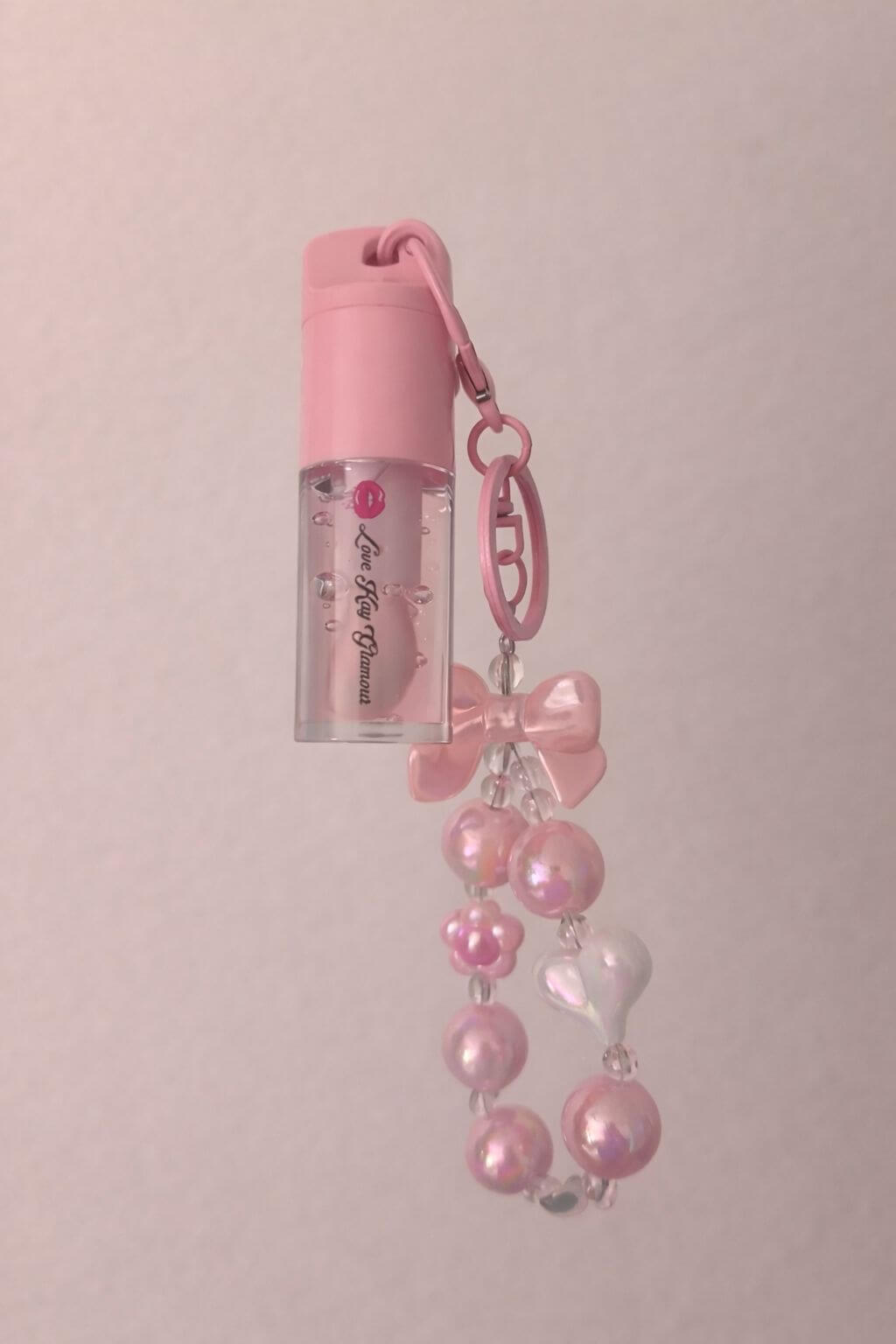 Watermelon Pop lip gloss with a cute pink bow and charm, perfect for kids' playful beauty.