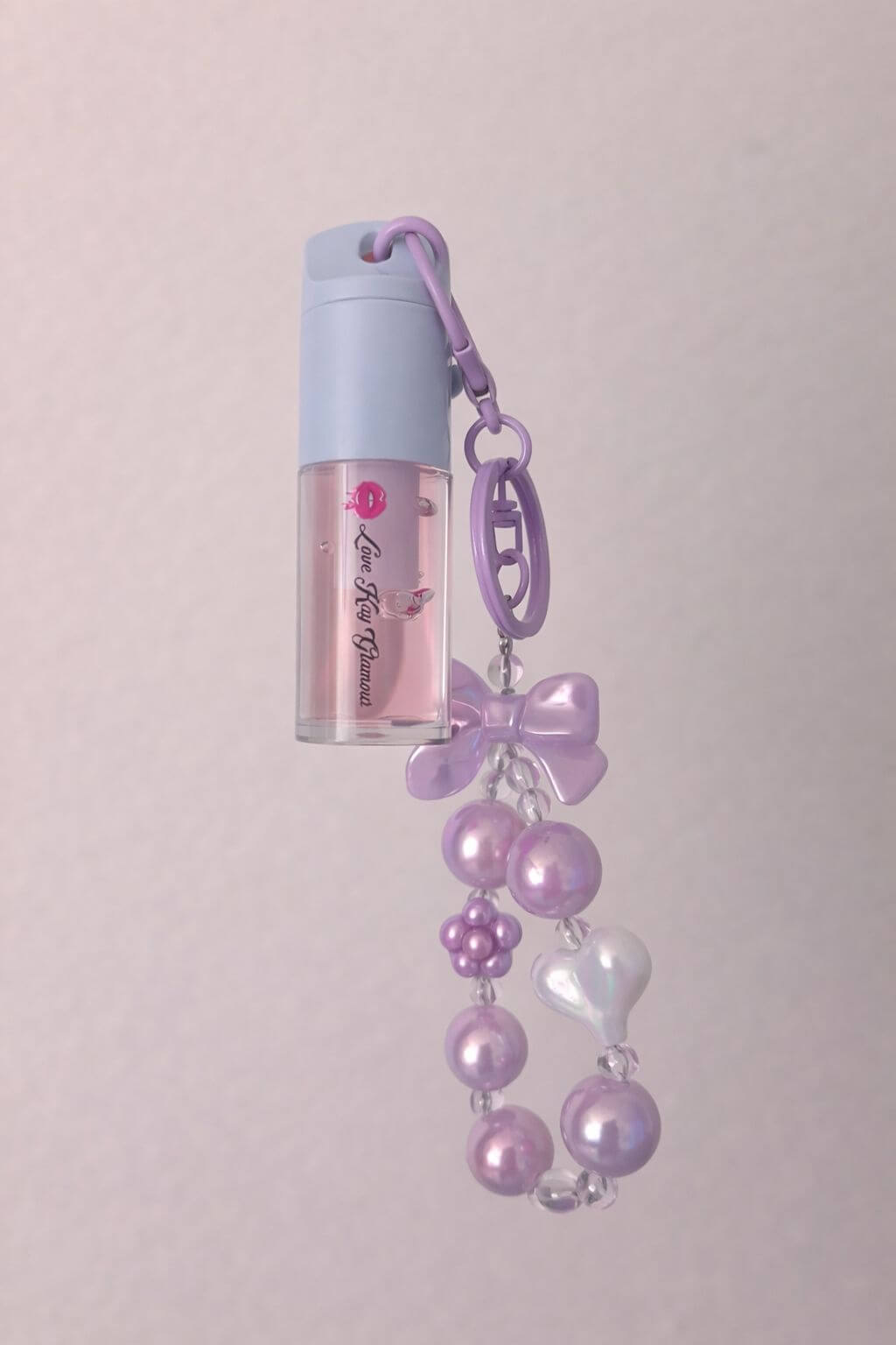 Strawberry Swirl lip gloss in a cute purple holder with beads and charms, perfect for kids.